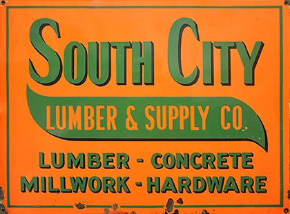 A South City Lumber & Supply Co. vintage metal sign with the words lumber, concrete, millwork, and hardware