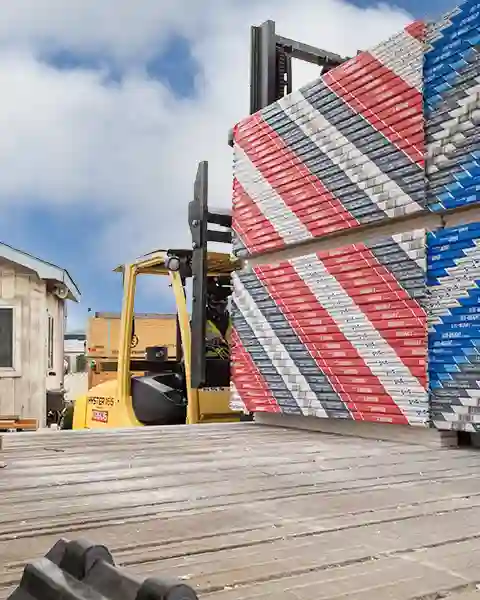 Stacked dry wall is delivered and unloaded by our forklift driver