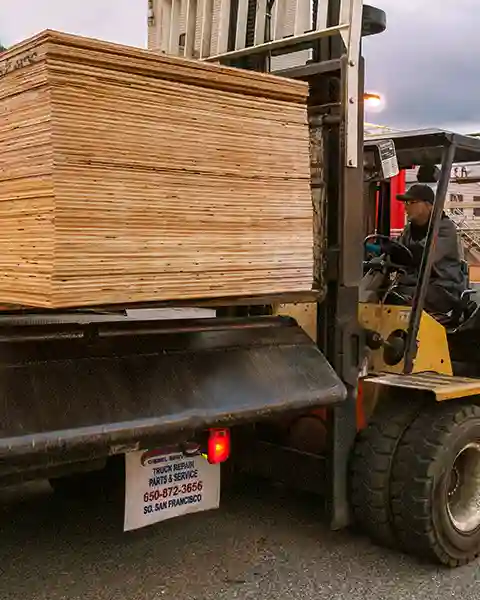 A bundle of 4x8 plywood is loaded onto one of our delivery trucks for local delivery