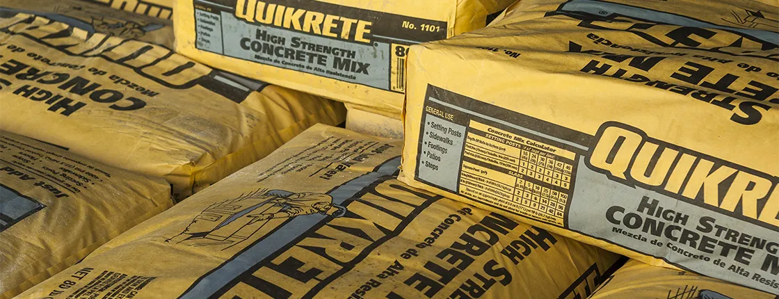 Stacked yellow bags of Quikrete High Strength Concrete Mix for general construction use