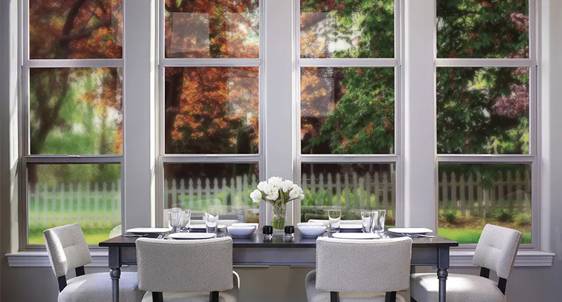 Simple elegance around the dinning room table featuring views of the garden through four Milgard Tuscany vinyl windows
