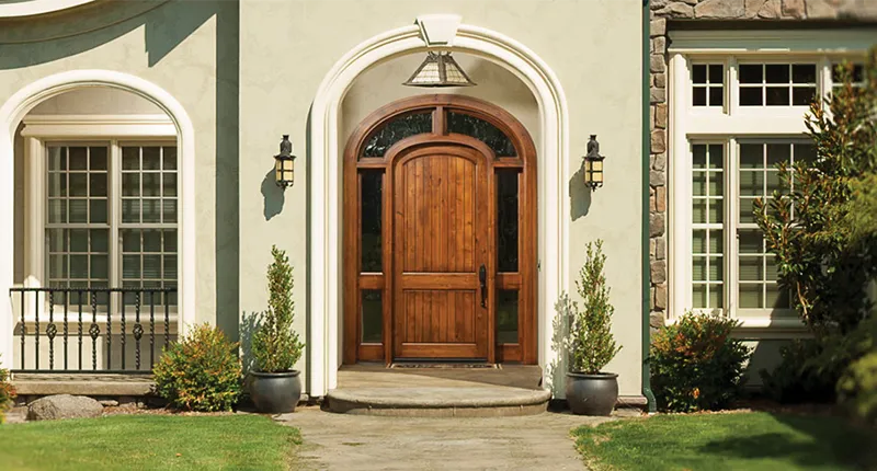 This Medeteriane style home features a rustic wood entry door by Rogue Valley Door with arched top, rustic wood side lites and arched transom to enhance the arched entry alcove