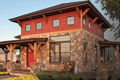 This stone and wood shingle Craftsman style home has plenty of curb appeal and features Ply Gem windows with divided lites and red front entry door
